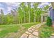 A stepping stone path leads to a home with a covered porch, set against a backdrop of lush trees at 555 E Valley Ne Rd, Rydal, GA 30171