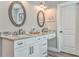 Bathroom boasts double vanity, granite countertops, framed mirrors, and hardwood floors at 555 E Valley Ne Rd, Rydal, GA 30171