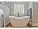 Bathroom features a freestanding tub, stylish faucets, stone accent wall, and window at 555 E Valley Ne Rd, Rydal, GA 30171