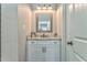 Bathroom vanity features granite countertops, cabinet storage, framed mirror, and decorative lighting at 555 E Valley Ne Rd, Rydal, GA 30171