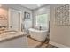 Bathroom features a freestanding tub, stylish faucets, stone accent wall, and decorative art at 555 E Valley Ne Rd, Rydal, GA 30171