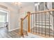 Hallway featuring staircase with wood and iron railing, wood floors and access to laundry room at 555 E Valley Ne Rd, Rydal, GA 30171