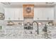 A kitchen with a large island and custom cabinetry and a wooden range hood at 555 E Valley Ne Rd, Rydal, GA 30171