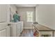 Laundry room features washer, dryer, storage, window, and hardwood floors at 555 E Valley Ne Rd, Rydal, GA 30171