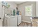 Laundry room features washer, dryer, storage, window, and hardwood floors at 555 E Valley Ne Rd, Rydal, GA 30171