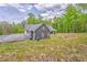 View of home from rear showing driveway and partial lawn with trees in background at 555 E Valley Ne Rd, Rydal, GA 30171