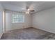 A spacious carpeted bedroom with natural light, featuring a ceiling fan and ample space for furniture at 5723 Fieldstone Dr, Lithonia, GA 30038