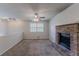 Cozy living room features a brick fireplace, ceiling fan, and neutral carpet at 5723 Fieldstone Dr, Lithonia, GA 30038