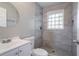 Bathroom showcasing shower with tiled walls, round mirror, and single sink vanity at 941 Reed Ave, Atlanta, GA 30344