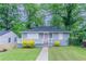 Charming home featuring a quaint porch with pink door and lovely landscaping at 941 Reed Ave, Atlanta, GA 30344