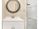Elegant bathroom featuring a round mirror and a vanity with white cabinets at 1398 Woodland Ave, Atlanta, GA 30316