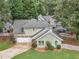 Aerial view of a well-manicured lawn, mature trees, and charming single-Gathering home with a driveway at 141 S Fairfield Dr, Peachtree City, GA 30269
