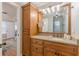 Bathroom with granite countertops, wood cabinets, and a large mirror at 141 S Fairfield Dr, Peachtree City, GA 30269