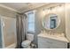Well-lit bathroom featuring a white vanity with a round mirror and a shower with gray curtain at 141 S Fairfield Dr, Peachtree City, GA 30269