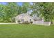 Beautifully landscaped front yard with lush green grass, flowering shrubs, and a white picket fence at 141 S Fairfield Dr, Peachtree City, GA 30269