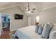 Well-lit main bedroom featuring wood floors, a ceiling fan, and a view into the ensuite bathroom at 141 S Fairfield Dr, Peachtree City, GA 30269