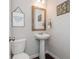 Small half bathroom features a pedestal sink, framed mirror, and neutral wall art at 2444 Coosa Vly, Atlanta, GA 30339