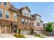 Well-maintained townhome featuring a brick facade, two-car garage, and manicured landscaping at 2444 Coosa Vly, Atlanta, GA 30339