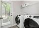 Modern laundry room featuring white front load washer and dryer, plus shelving at 2444 Coosa Vly, Atlanta, GA 30339