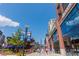 Street view of shops and restaurants with PPG banners and people walking under a sunny sky at 2444 Coosa Vly, Atlanta, GA 30339