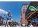 View of bustling street with Wahlburgers restaurant, banners, and pedestrians under a sunny sky at 2444 Coosa Vly, Atlanta, GA 30339