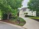 The property includes a large driveway and an attached three-car garage, surrounded by mature trees at 365 Autumn Breeze Dr, Roswell, GA 30075