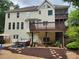 Exterior view of a multi-story home with a spacious deck, patio, and hot tub in a landscaped backyard at 365 Autumn Breeze Dr, Roswell, GA 30075