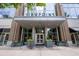 Elegant condo building entrance with glass doors, brick accents, and stylish planters for a welcoming arrival at 855 Peachtree Ne St # 2713, Atlanta, GA 30308