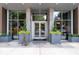 Elegant building entrance with glass doors, brick accents, and stylish planters for a welcoming arrival at 855 Peachtree Ne St # 2713, Atlanta, GA 30308