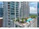 Exterior of a modern high-rise building with a rooftop pool, seating, and green landscaping at 855 Peachtree Ne St # 2713, Atlanta, GA 30308