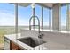 Kitchen island with stainless steel sink, modern faucet, quartz countertop, and floor-to-ceiling windows with city views at 855 Peachtree Ne St # 2713, Atlanta, GA 30308