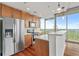 Modern kitchen with stainless steel appliances, wood cabinets, hardwood floors, and a breakfast bar with city views at 855 Peachtree Ne St # 2713, Atlanta, GA 30308