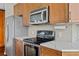 Well-lit kitchen featuring stainless steel appliances, wood cabinets, tile backsplash, and quartz countertops at 855 Peachtree Ne St # 2713, Atlanta, GA 30308