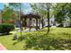 View of a neighborhood gazebo in a grassy common area for residents and visitors at 4964 Villager Ln, Stone Mountain, GA 30083