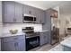 This kitchen features stainless steel appliances, gray cabinets, granite countertops, and tile backsplash at 4964 Villager Ln, Stone Mountain, GA 30083