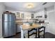 Well-lit kitchen with white cabinetry, stainless steel refrigerator, and island with seating at 5 Newport Nw Pl, Atlanta, GA 30318