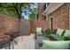 Private brick patio with comfortable seating area, table, and beautiful mature plants at 5 Newport Nw Pl, Atlanta, GA 30318