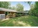 Grassy backyard behind a red brick home featuring an AC unit and a range of shrubbery at 6835 Castleton Dr, Sandy Springs, GA 30328