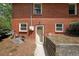 Back exterior of brick home featuring an access door, utility installations, and lawn at 6835 Castleton Dr, Sandy Springs, GA 30328