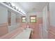 Full bathroom with pink tile, bathtub and walk-in shower, and a wide mirror over the sink at 6835 Castleton Dr, Sandy Springs, GA 30328