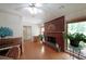 Cozy living room featuring a brick fireplace, hardwood floors, and ample natural light at 6835 Castleton Dr, Sandy Springs, GA 30328