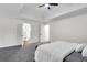 Spacious bedroom featuring tray ceilings, plush gray carpeting, and white bedding for a serene retreat at 1172 Rockmart Nw Cir, Kennesaw, GA 30144