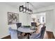 Elegant dining room with a modern chandelier, plush velvet chairs, and an open view into the living area at 1172 Rockmart Nw Cir, Kennesaw, GA 30144