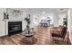 Open living room features modern fireplace, rich wood floors, and seamless flow to the bright, white kitchen at 1172 Rockmart Nw Cir, Kennesaw, GA 30144