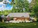 Brick home featuring a large patio surrounded by lush landscaping and mature trees at 2151 Desmond Dr, Decatur, GA 30033