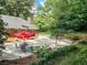 Private backyard featuring a spacious patio, landscaping, and an outdoor dining area with a red umbrella at 2151 Desmond Dr, Decatur, GA 30033