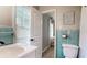 Bathroom featuring a toilet, blue tile accents, and a sink with natural light streaming through the window at 2151 Desmond Dr, Decatur, GA 30033