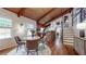 Dining area showcases a round table, wooden beams, exposed brick, and access to the kitchen at 2151 Desmond Dr, Decatur, GA 30033
