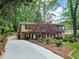 View of a two-story brick home with driveway, well-manicured landscaping, and mature trees at 2151 Desmond Dr, Decatur, GA 30033
