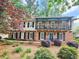 Two-story brick home featuring a balcony, landscaped front yard, black shutters, and a blue front door at 2151 Desmond Dr, Decatur, GA 30033